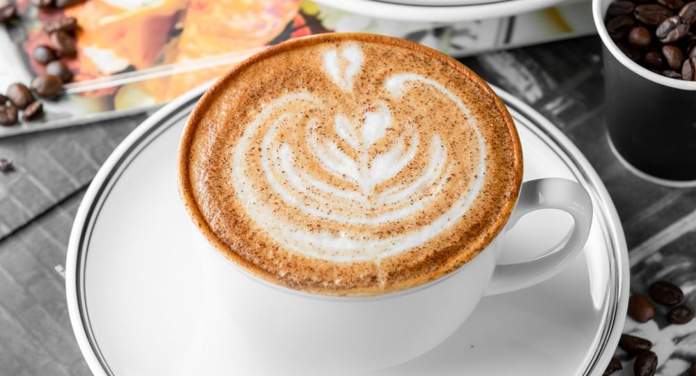 close up of cup of cappuccino coffee and chocolate cake
