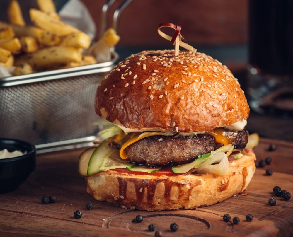 huge burger with fried meat and vegetables